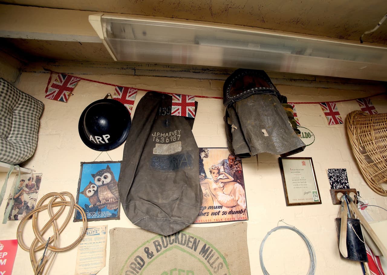 Cascos, morrales y máscaras cuelgan en las paredes.