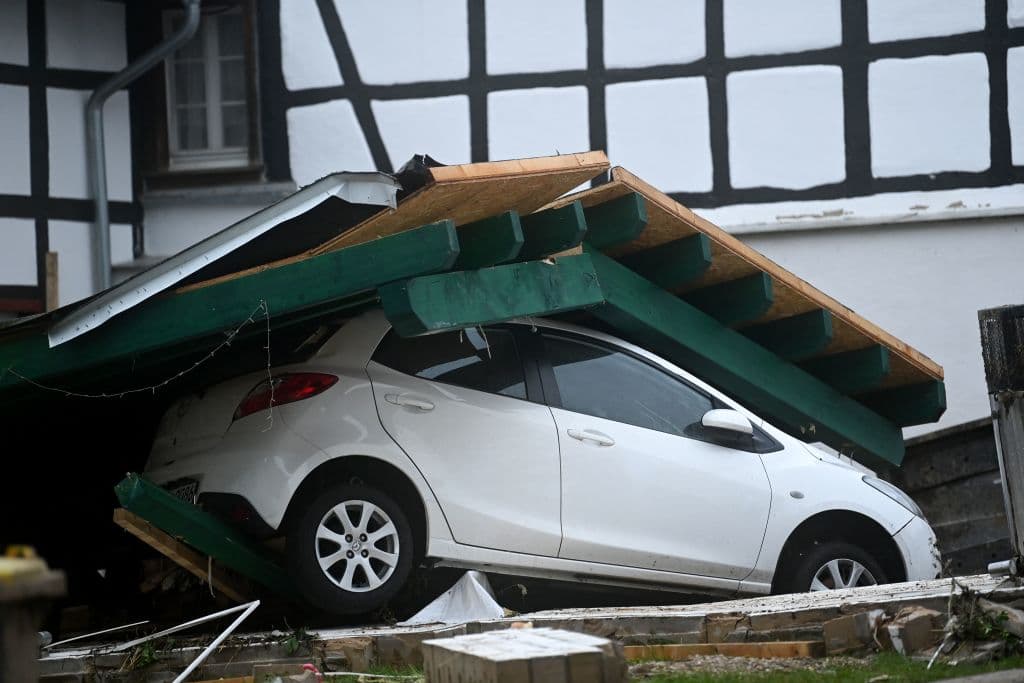 Un automóvil cubierto de escombros en Iversheim, en el oeste de Alemania, este 16 de julio. Muchos científicos expertos en clima, citados por la agencia AP, dijeron que el vínculo de este tipo de tormentas y el calentamiento global era "ineludible". Aunque no se puede afirmar que el cambio climático causó las inundaciones,
<b> científicos insisten en que los climas extremos se agravan por este fenómeno. </b>