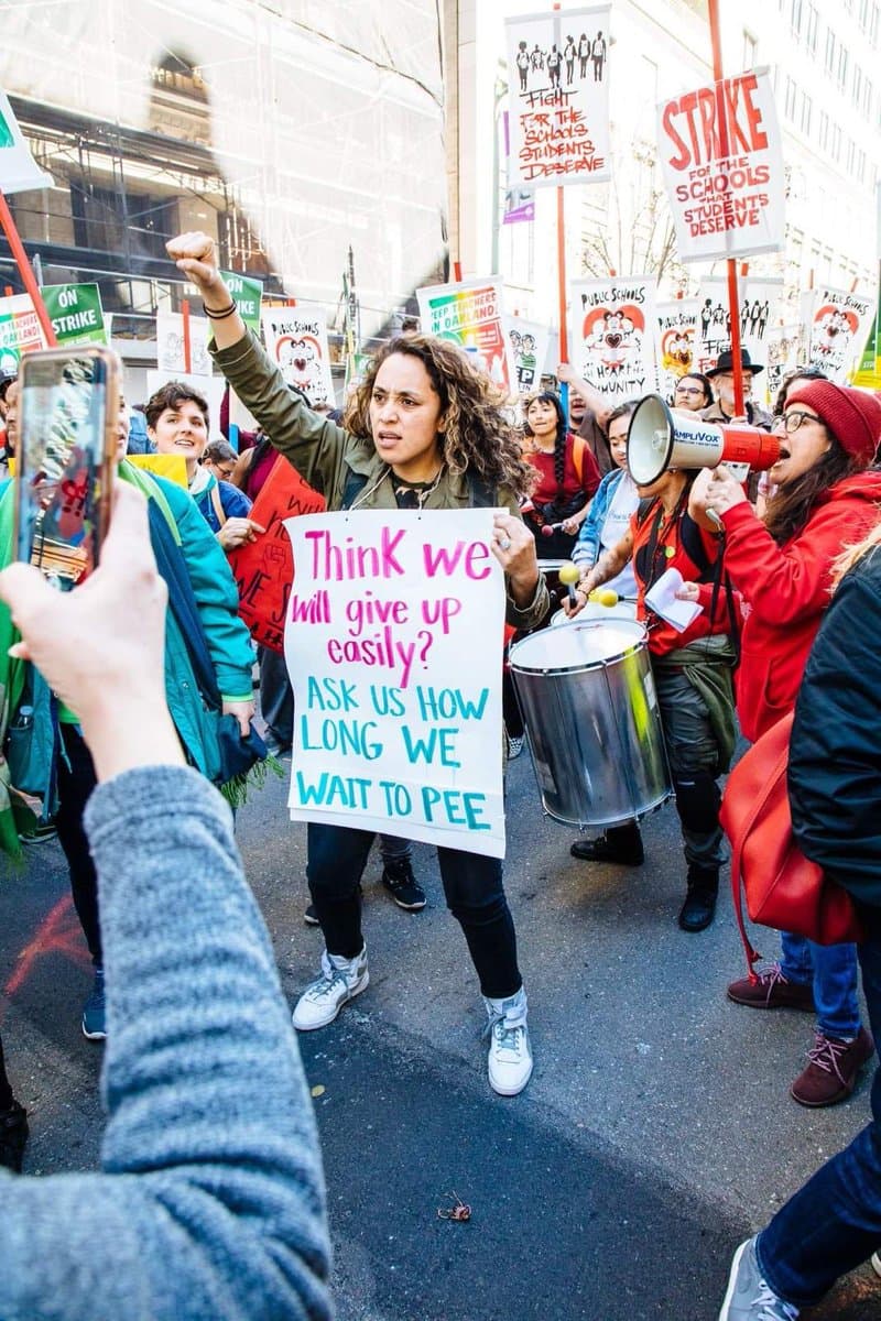 El ingenio de esta maestra fue evidente y captó la atención de muchos de los manifestantes. "¿Crees que nos daremos por vencido tan fácil? Pregúntanos cuánto tenemos que esperar para poder ir al baño". No es extraño que los profesores de escuelas públicas se quejen de los diminutos recesos que pueden tomar durante el día, incluso para atender las necesidades básicas.