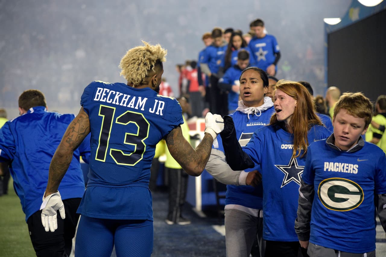 NFC receiver Odell Beckham Jr. (13) fist bumps with children that took part in pre-game festivities on the field before the NFL Pro Bowl football game against the AFC in Orlando, Fla., Sunday, Jan. 29, 2017. (AP Photo/Phelan M. Ebenhack)