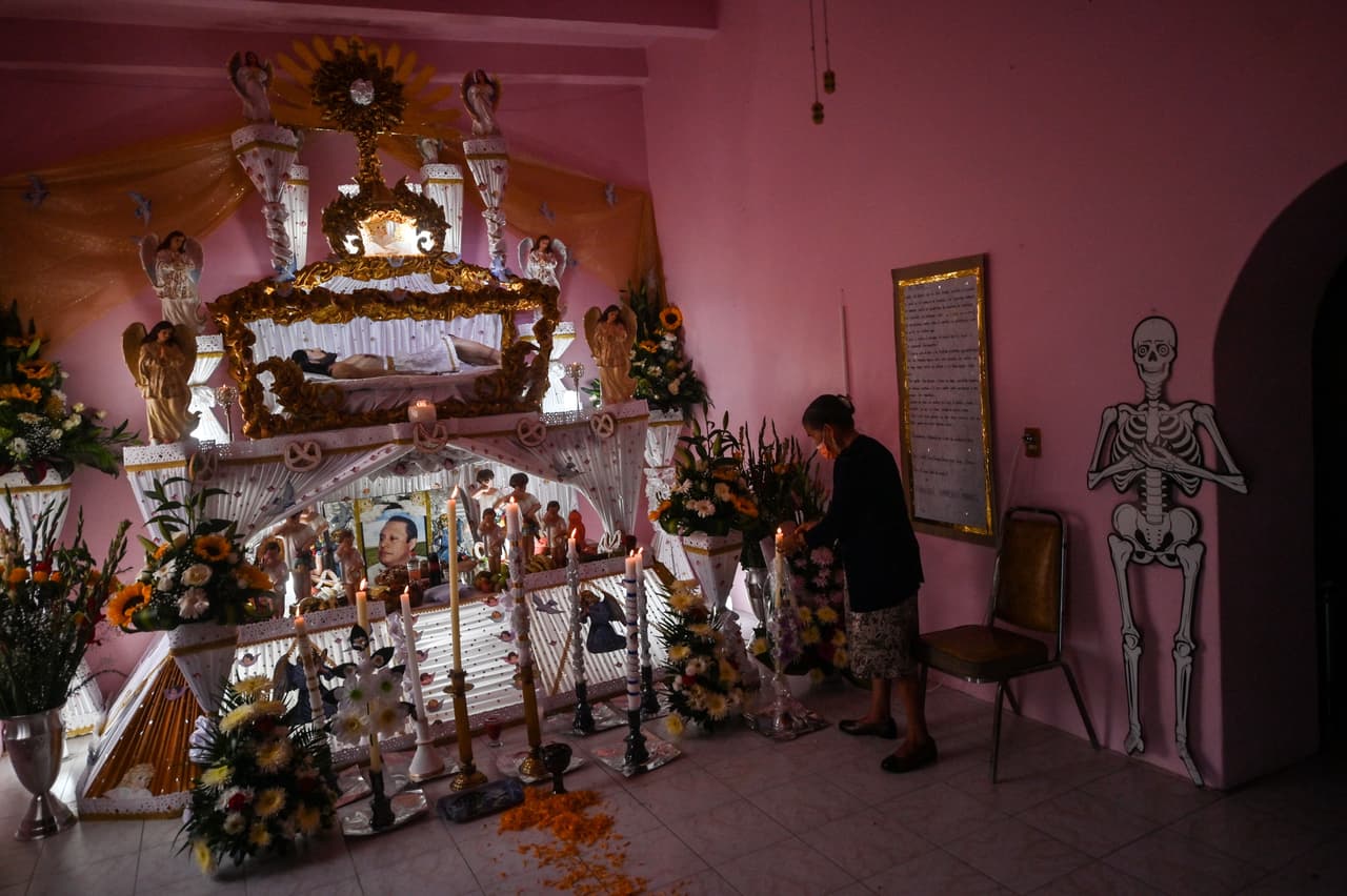 María Antonieta Ramírez, de 75 años, enciende una vela en un Altar Monumental dedicado a su esposo Francisco Sarmiento, de 77 años.