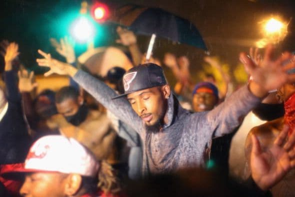 “Somos Michael Brown”, coreó el grupo de manifestantes conforme alzaba las manos al aire, en lo que se ha convertido en el símbolo de sus protestas por el supuesto abuso de la fuerza policial.