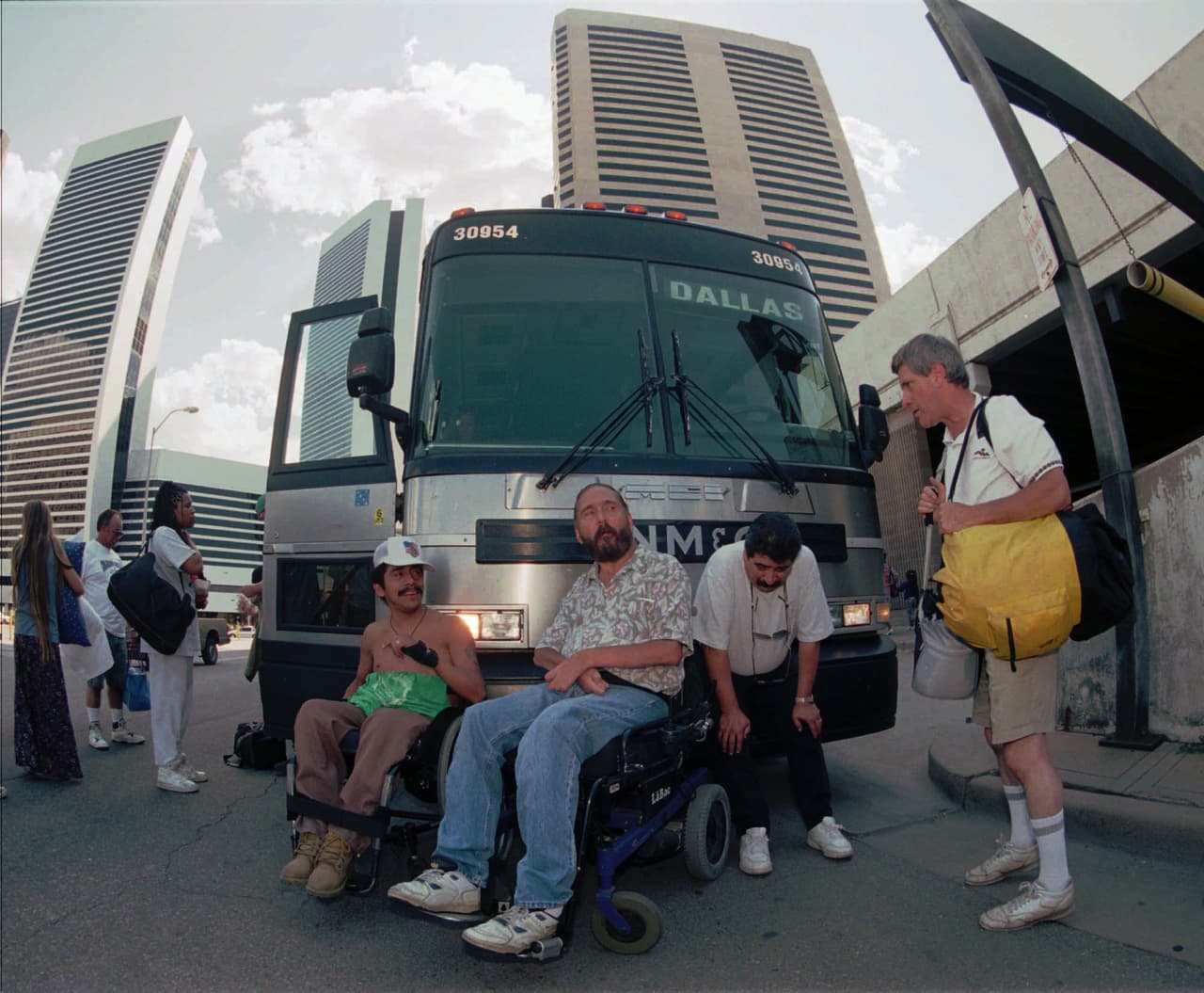 Los orígenes de ADAPT se remontan al 5 de julio de 1978, cuando 
<b>25 personas discapacitadas obstruyeron el tráfico para exigir algo que no habían podido alcanzar por otros medios: poder usar el transporte público</b>. Se colocaron frente y detrás de autobuses de la ciudad que no podían usar porque no tenían accesibilidad. Esta forma de protesta se ha repetido a lo largo de los años. En la imagen, dos hombres bloquean el paso de un bus en Denver en 1997.