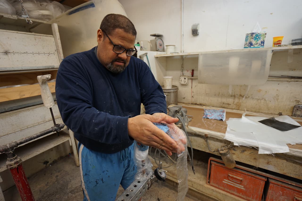 André se dedica a laminar, lo que implica recubrir la prótesis con resina.