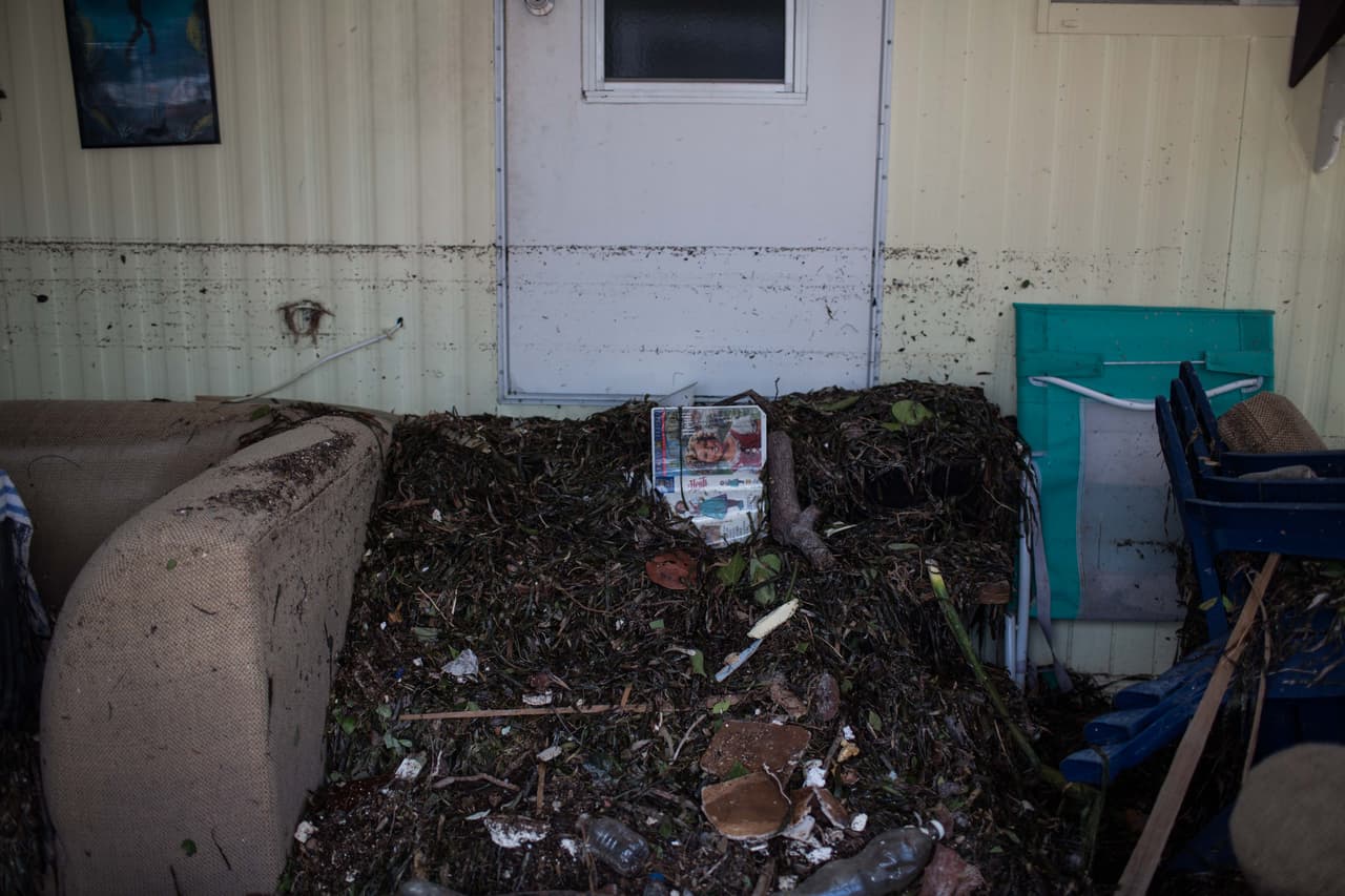 Una revista yace sepultada en desperdicios dentro de una casa en los Cayos de Florida. La línea negra horizontal marca el nivel del agua durante el huracán Irma. Almudena Toral/Univision Digital