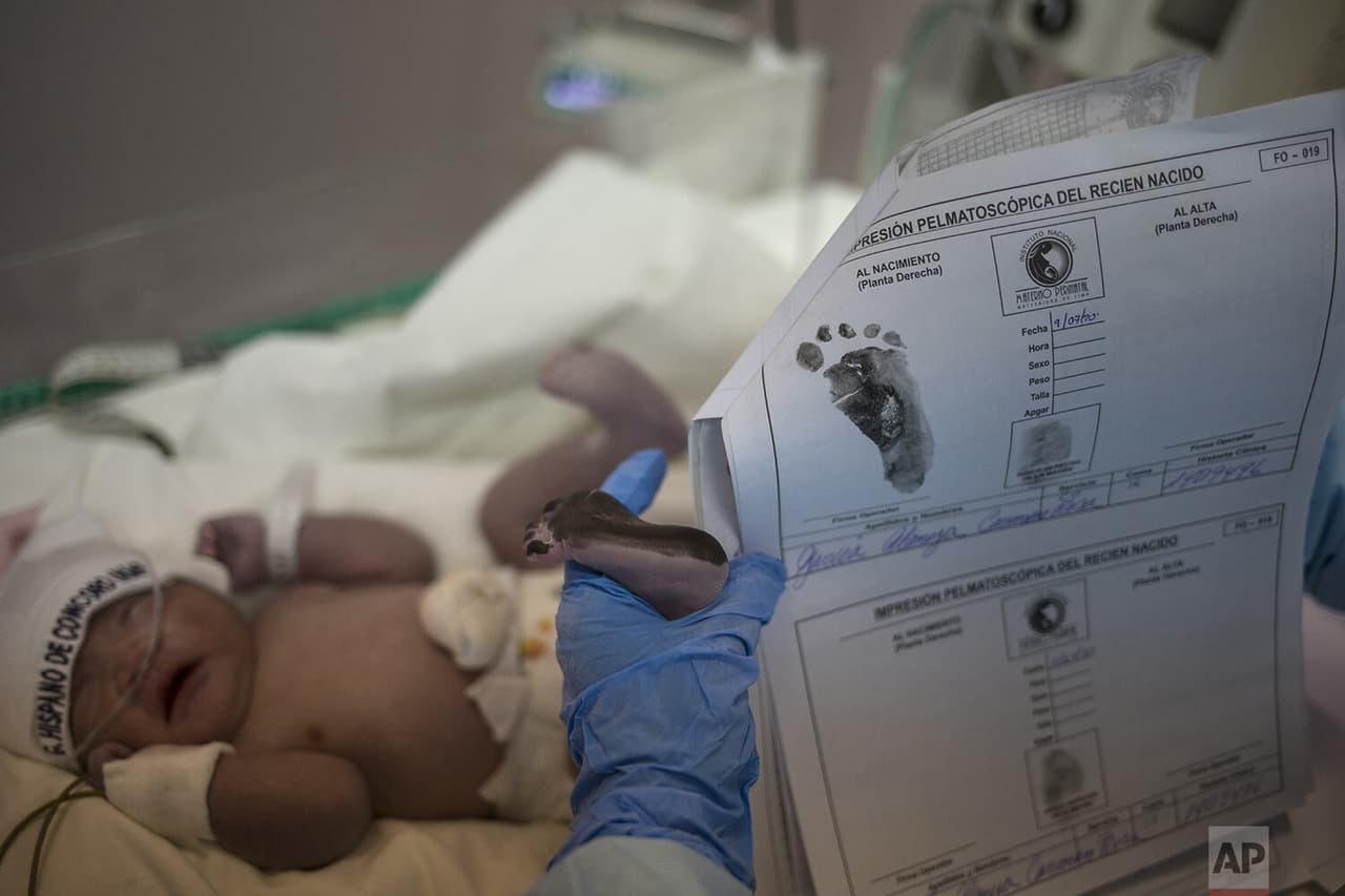 Una enfermera 
<b>registra las huellas de un bebé recién nacido </b>en un área aislada reservada para las madres infectadas con covid-19.