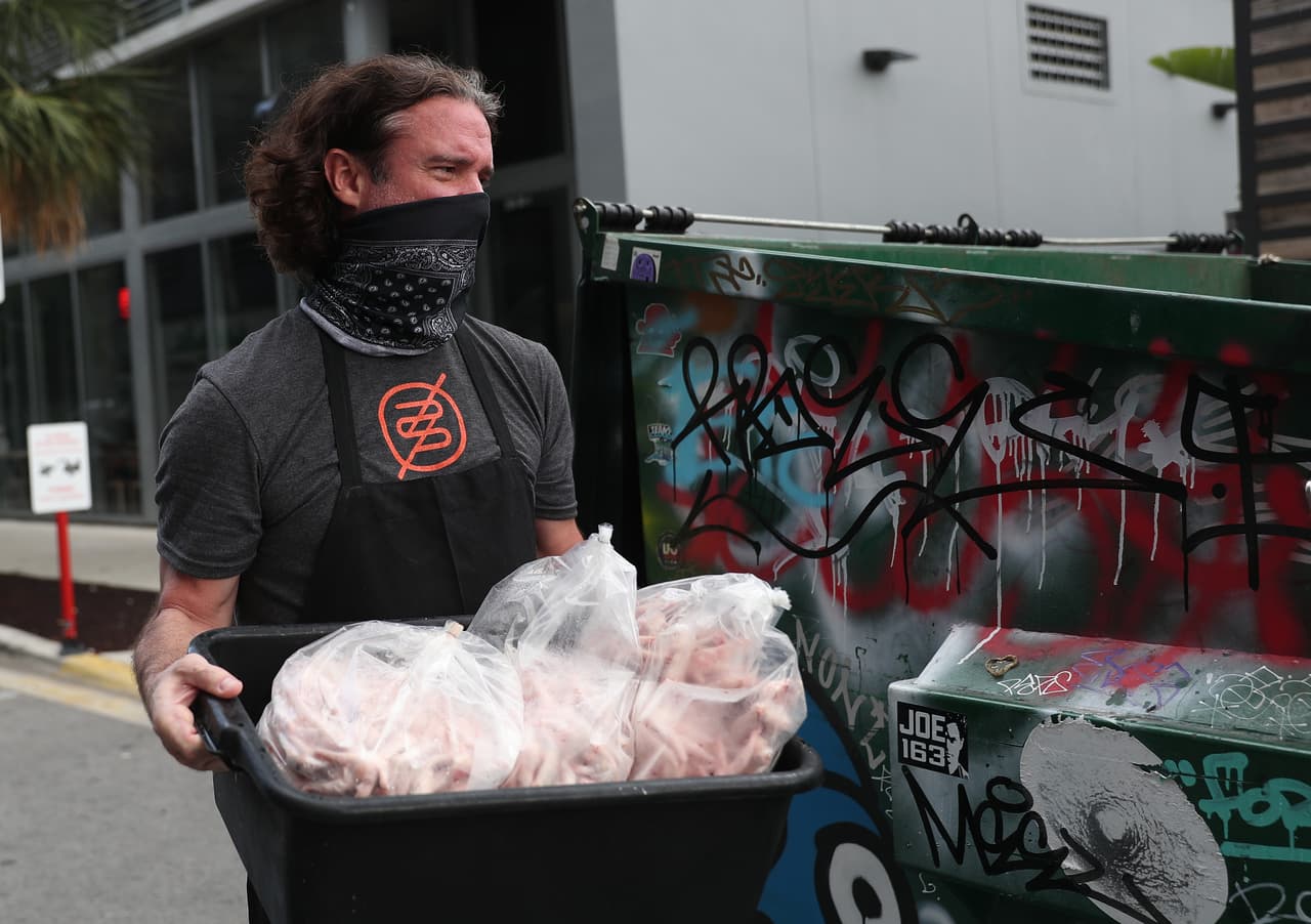 En esta imagen, uno de los dueños del restaurante Buya, lleva a la basura la comida de su refrigerador, después de tener que cerrar nuevamente el pasado 8 de julio.