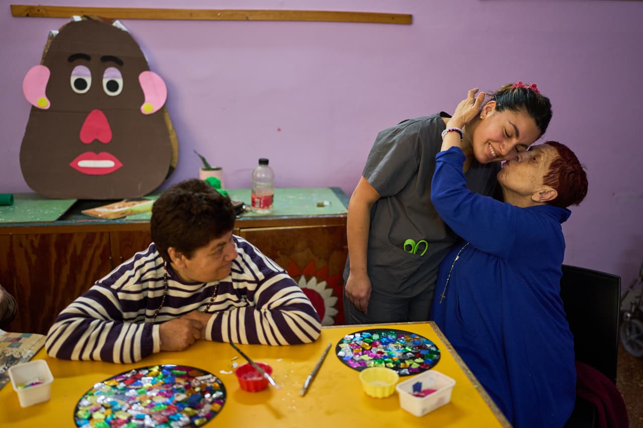 Stella Maris Fernández besa a su instructora Lucía Carrera durante un taller de arte en el Pequeño Cottolengo Don Orione.