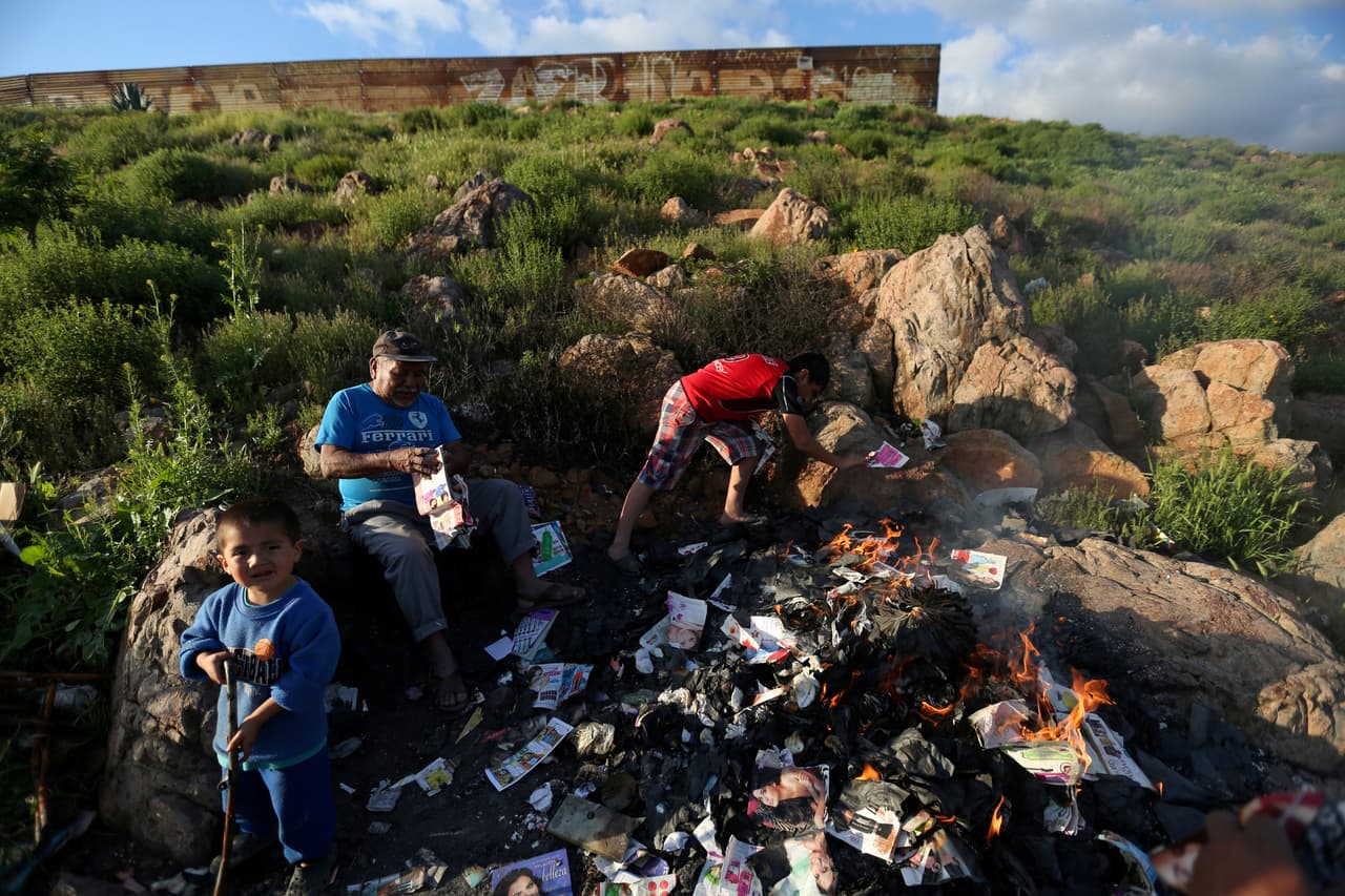 Una familia quema basura en las afueras de Tijuana.