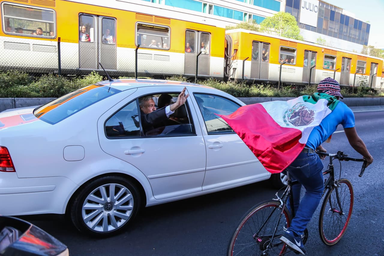 Simpatizantes del mandatario electo de México, Andrés Manuel López Obrador, le saludan por calles de Ciudad de México rumbo a la Cámara de Diputados para su juramentación.