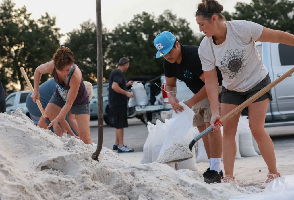 Las personas van con palas para llenar los sacos de arena en el Parque Helen Howarth Park en el condado Pinellas.