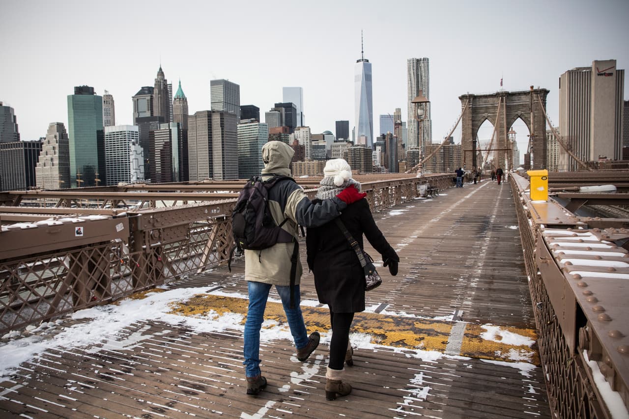 Una pareja cruza caminando el puente con la nueva torre del World Trade Center de fondo, en 2015.