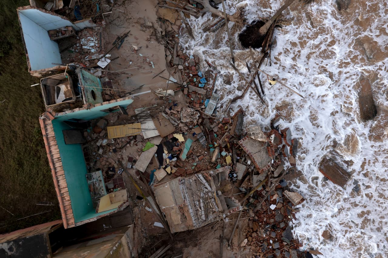 Vista aérea de un hombre recogiendo escombros de una casa que cayó el día anterior en la playa de Atafona.
<br>
<br>