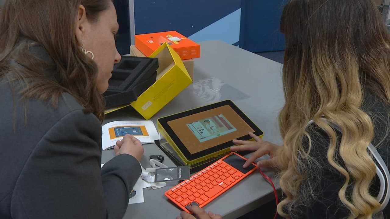 Cassandra arma su propia computadora con la supervisión de una funcionaria de la organización Family Strengthening.