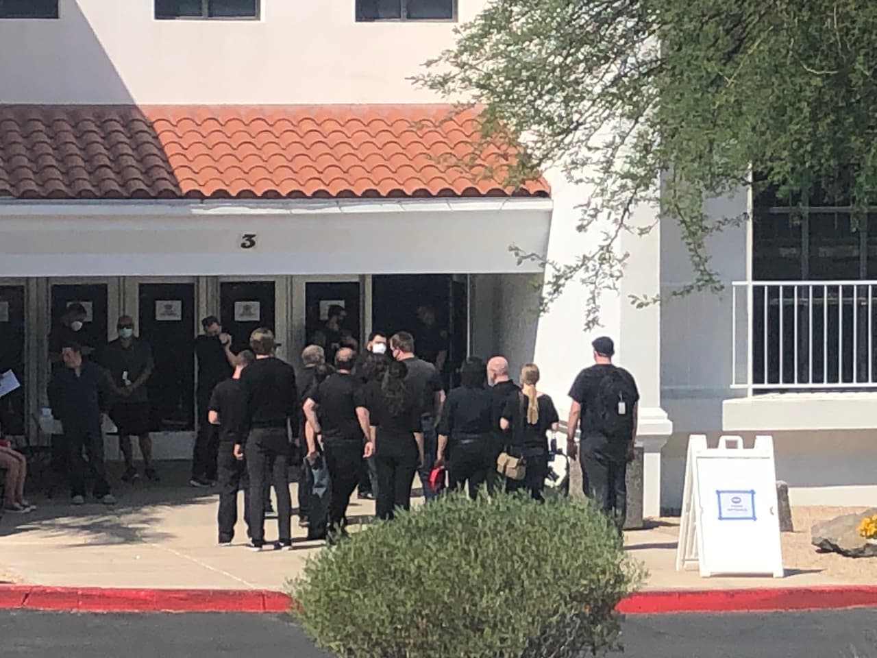 Se observa que los organizadores usan cubrebocas mientras se preparan para ingresar al lugar.