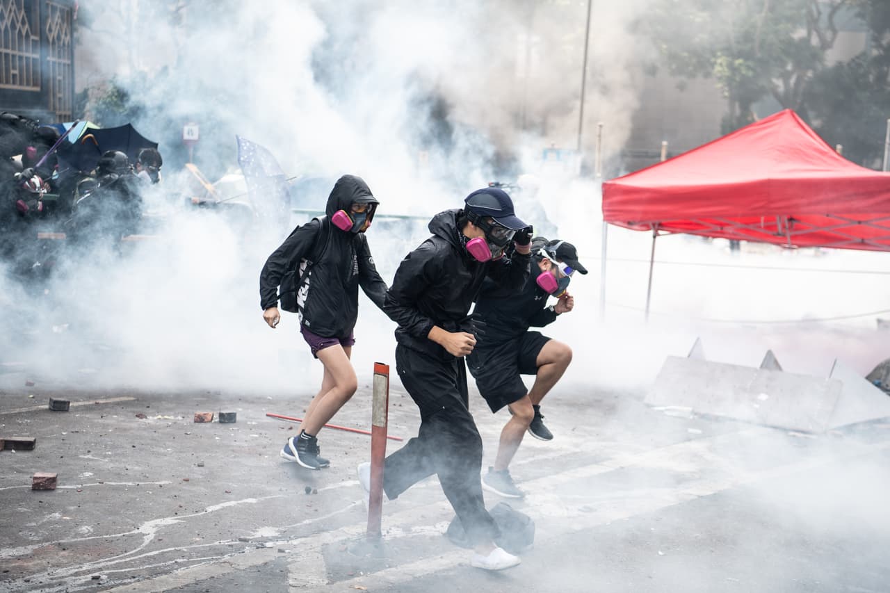 Tres manifestantes huyen de la policía en la Universidad Politécnica de Hong Kong. Las fuerzas de seguridad sitiaron este lunes ese centro eduativo, disparando balas de goma y gas lacrimógeno para detener a quienes participan en marchas antigubernamentales armados con cócteles molotov.
<br>