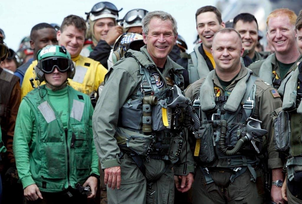 ARCHIVO - El presidente George W. Bush posa con marineros y pilotos a bordo del USS Abraham Lincoln frente a la costa de California tras aterrizar en un pequeño avión a reacción el 1 de mayo de 2003. (Foto AP/J. Scott Applewhite, Archivo)