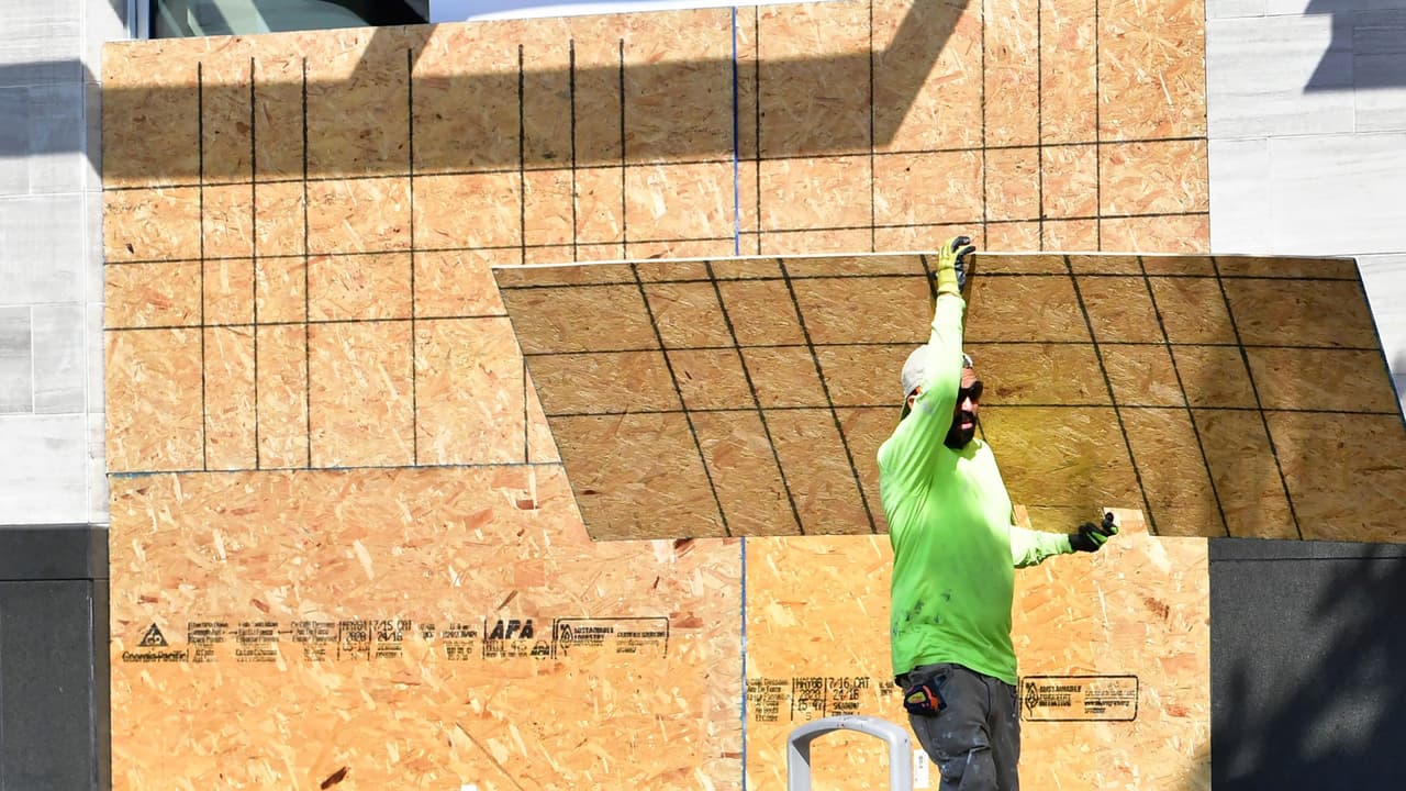 Empleados de la construcción instalando tablas de madera en las ventanas y puertas de los negocios son vistos horas antes de las elecciones generales en Santa Mónica, Long Beach y Beverly Hills. Comerciantes buscan evitar pérdidas y afectaciones en caso de que se presenten actos violentos durante las votaciones.