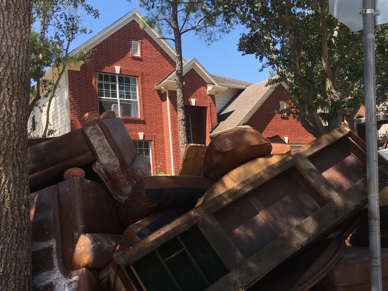 Escombros en la acera de la residencia de Cindy y Javier Ramírez, en el vecindario Canyon Gate de Katy, Texas.