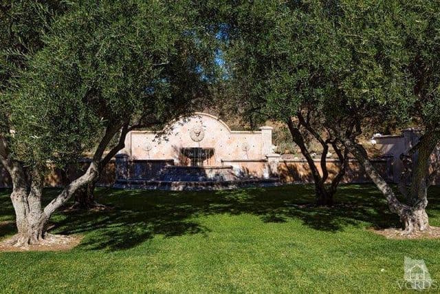 Es muy probable que los niños chapoteen en la fuente circular y ostentosa que se encuentra rodeada de árboles.