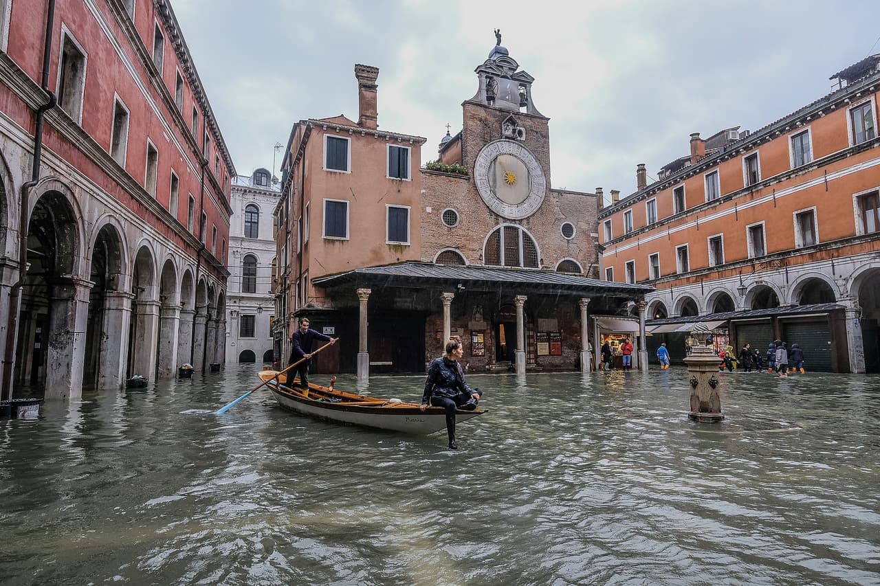 Una embarcación tradicional navega en una plaza inundada frente a una iglesia en Venecia. Al menos seis personas perdieron la vida por los árboles derribados por las fuertes lluvias y vientos en toda Italia.
