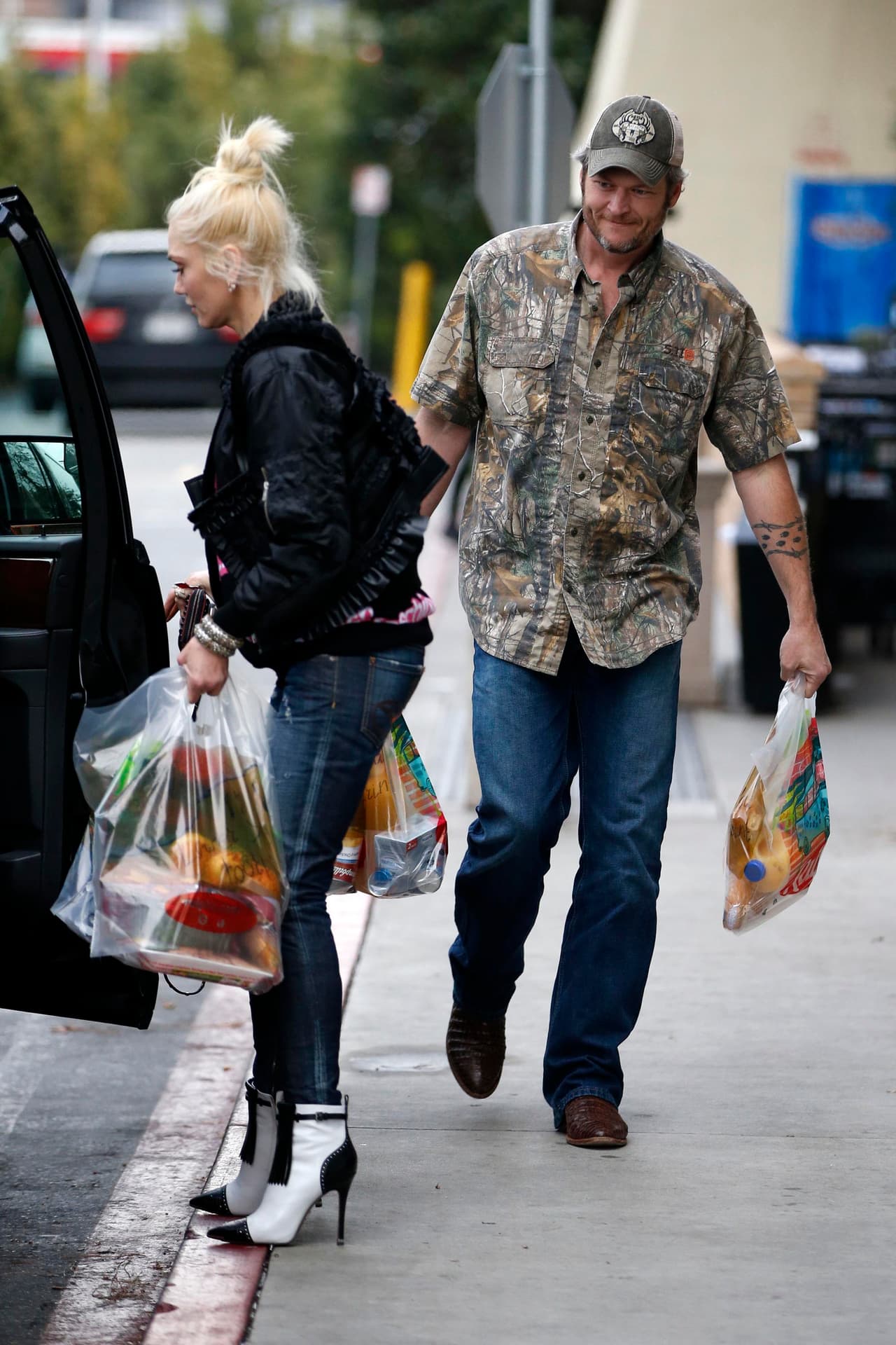 Blake Shelton y Gwen Stefani saliendo del supermercado.