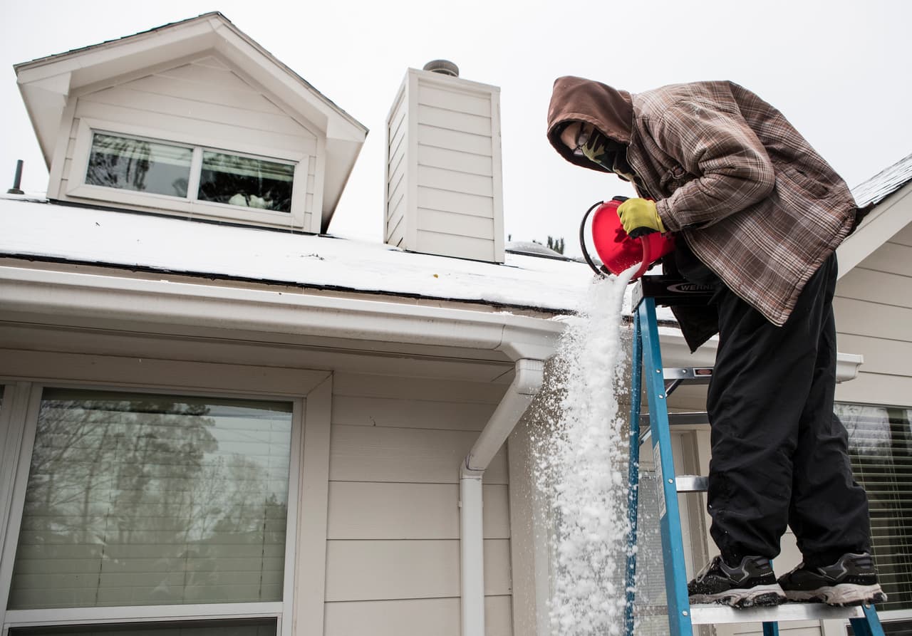 En Houston, Texas, la cuarta ciudad más poblada del país la mayoría de las autopistas fueron clausuradas. En la fotografía, un residente de Spring, al norte de Houston, quita la nieve del techo de su residencia.