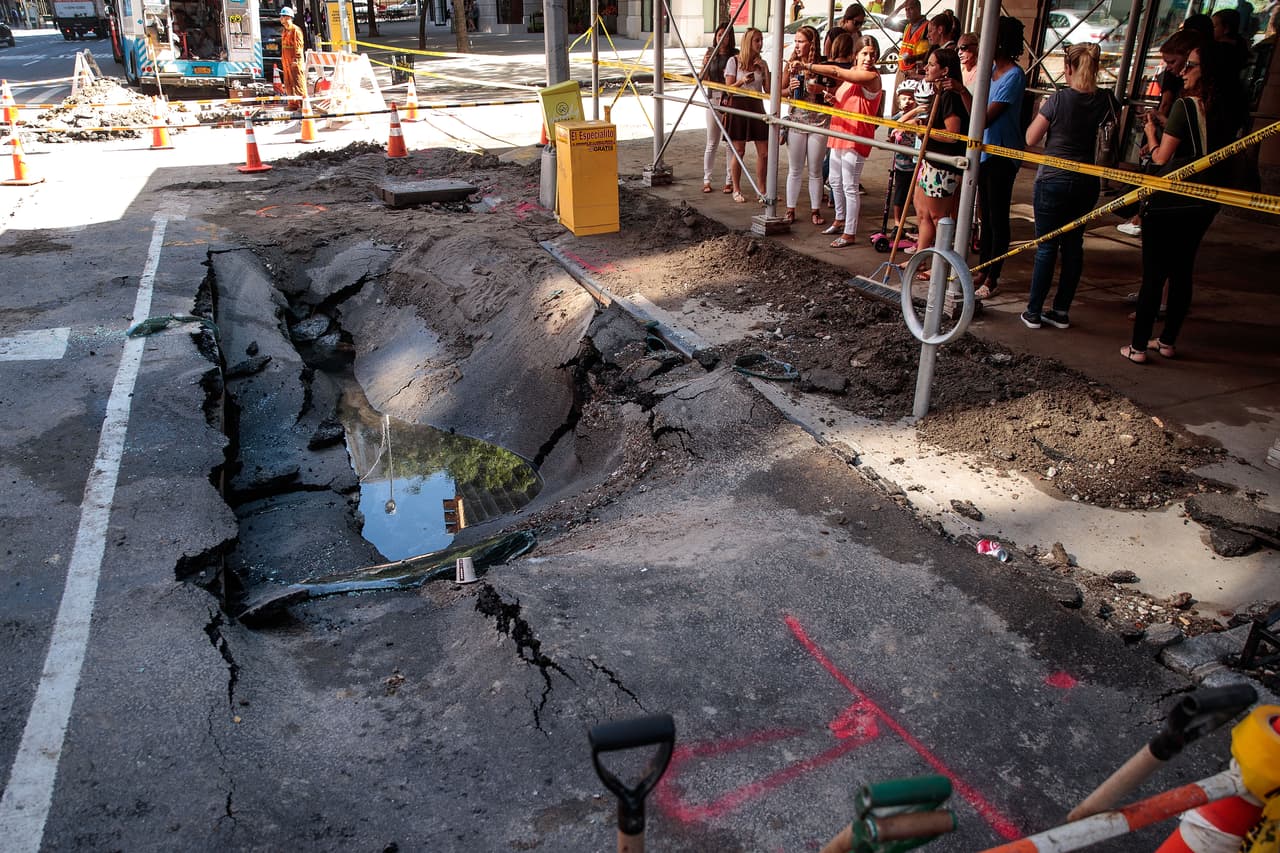 En agua estancada se refleja el día en Manhattan, uno complicado para los trabajadores que buscan la causa del rompimiento de la tubería.