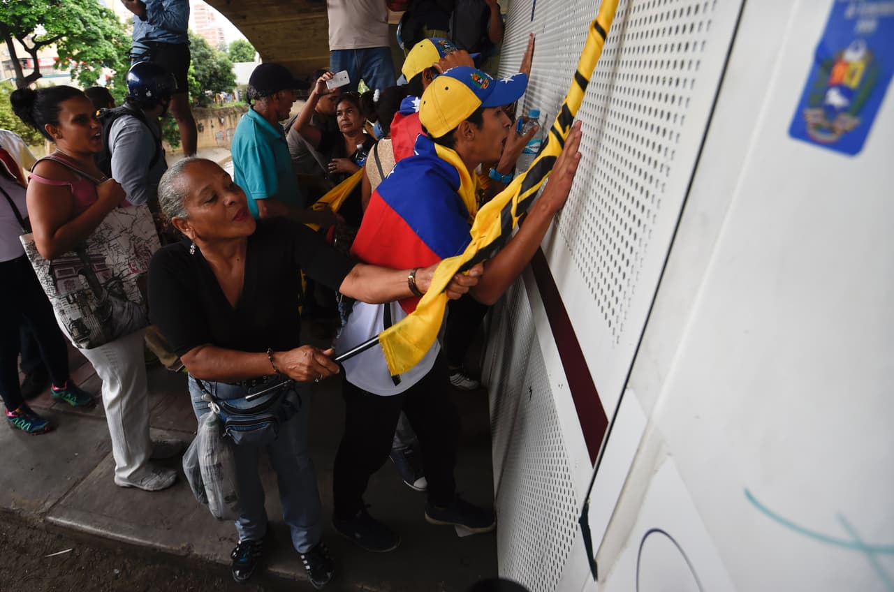 Manifestantes de la oposición junto al vehículo antidisturbios de la Policía Nacional durante la marcha en Caracas. Su objetivo era exigir acelerar el proceso de referendo revocatorio contra el presidente Nicolás Maduro, pero fueron repelidos por fuerzas antimotines.