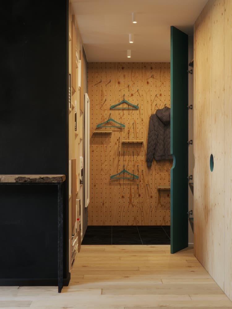 Un muro de madera conglomerada con orificios permite darse el lujo de tener un walk in closet.