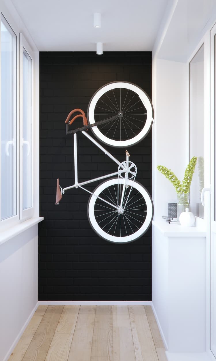 El muro de fondo del pasillo, pintado de negro, sirve de marco para destacar el diseño de la bicicleta que, colgada, ocupa el mínimo de espacio y se convierte en objeto decorativo.
