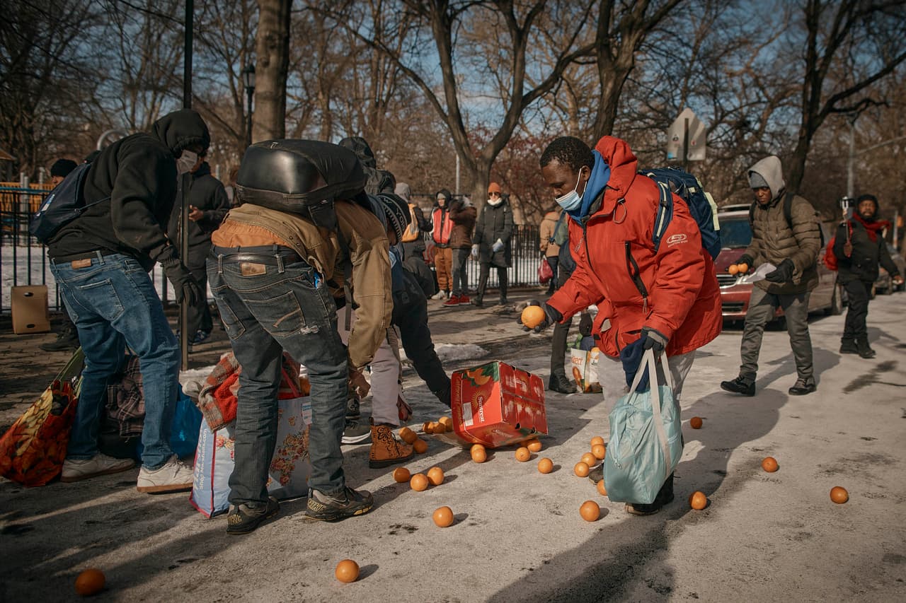 Los migrantes recogen naranjas a las afueras del St. Brigid Elementary School.