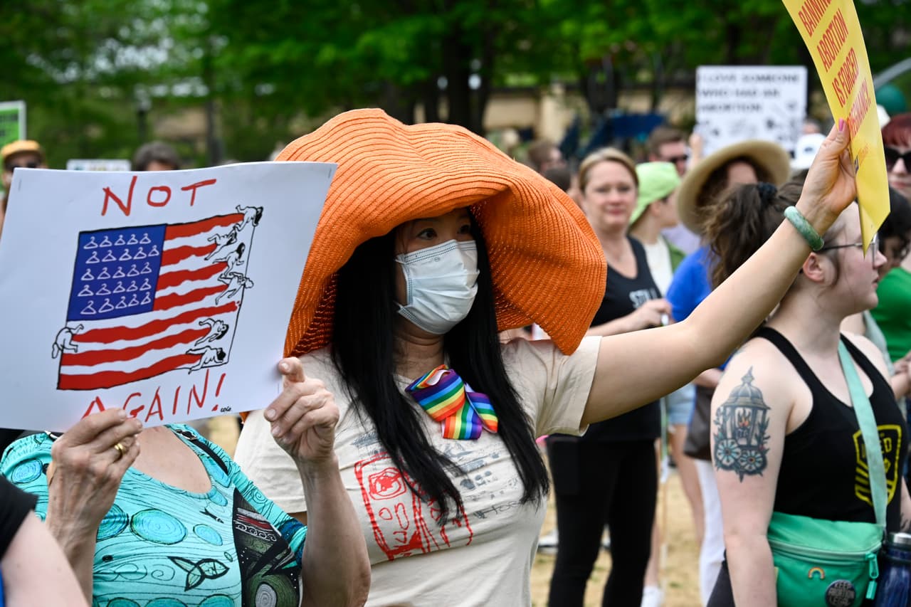 Esta manifestante de Chicago muestra una pancarta con una versión de la bandera de Estados Unidos en la que se ve la sangre de mujeres que dibuja las franjas rojas y ganchos de ropa marcando las estrellas.