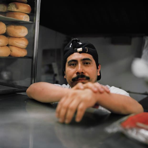 Pedro Guillermo Curiel en el minimercado donde trabaja. Está a cargo de tomar las órdenes de sándwiches en el deli.