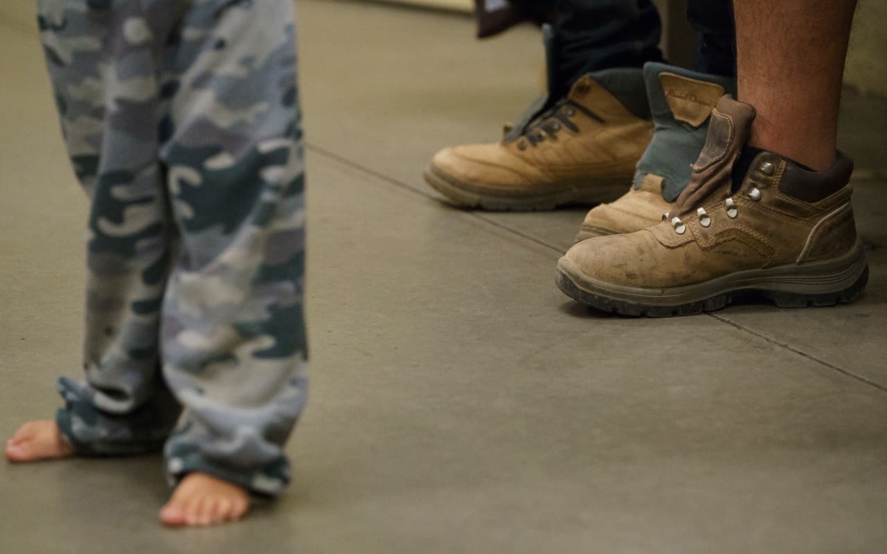 Menores inmigrantes con los pies descalzos y zapatos sin cordones en el centro de procesamiento de la Patrulla Fronteriza en Tucson, Arizona, este jueves 28 de junio de 2018, durante una visita de la primera dama Melania Trump. (AP Photo / Carolyn Kaster)