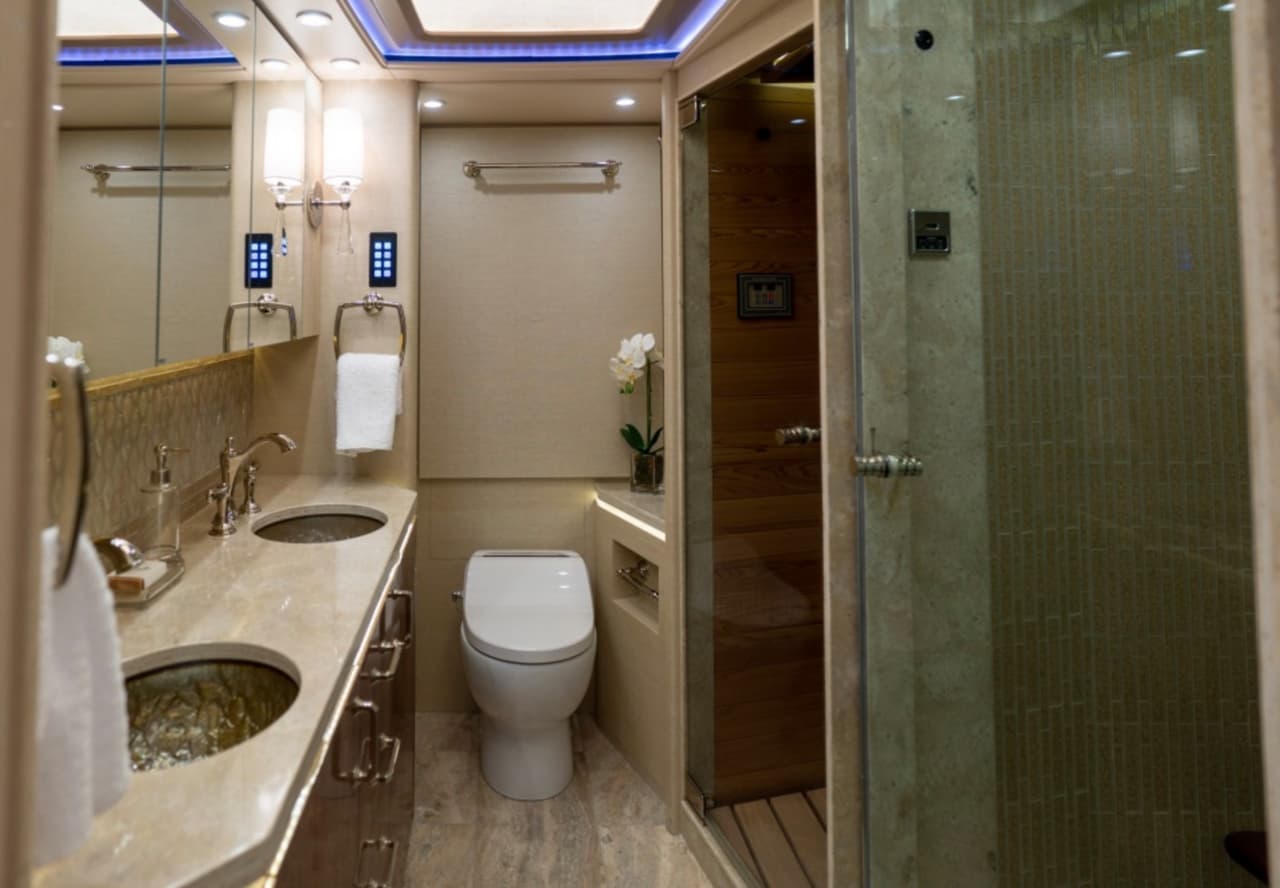 La regadera está separada por una puerta de cristal.