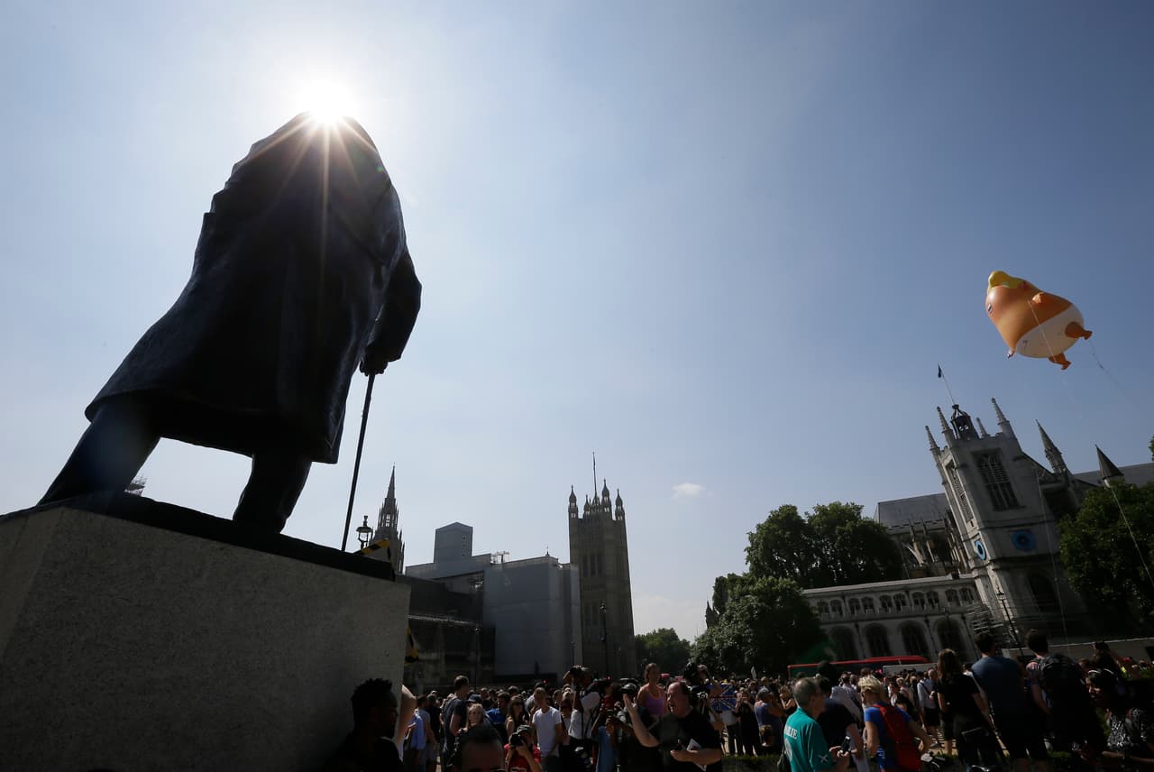 En primer plano la estatua del ex primer ministro británico Winston Churchill, al fondo vuela el 'Bebé Trump’.