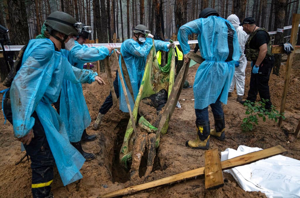 En esta fotografía, se observa a trabajadores durante la labor de exhumación del cuerpo de un civil. Una operación similar realizaron con los cientos de restos hallados en el lugar.