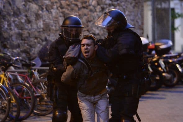 Los agentes de policía detienen a un hombre durante los enfrentamientos entre policías y manifestantes tras el desalojo de los activistas en Barcelona.