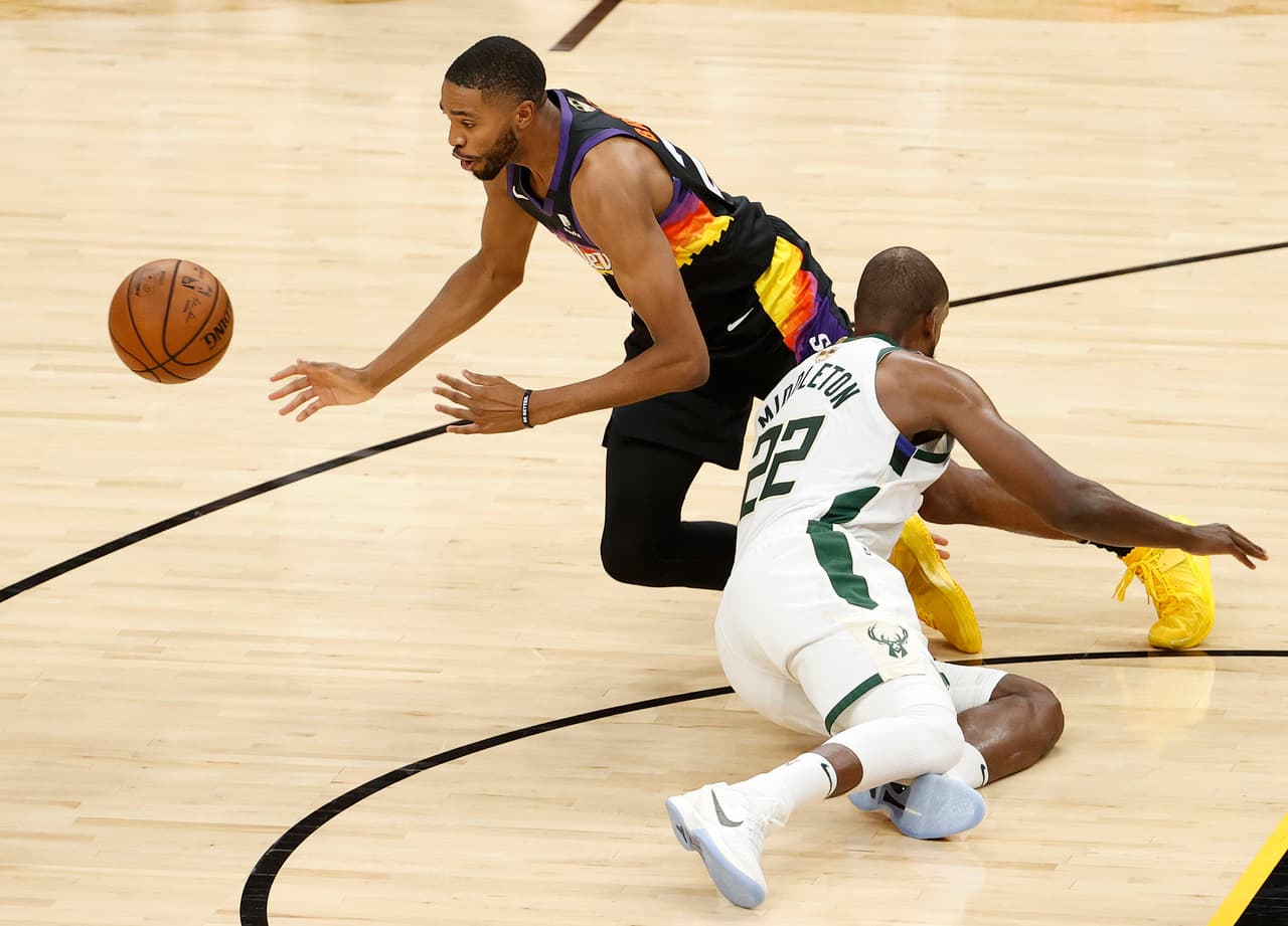 Mikal Bridges # 25 de los Phoenix Suns y Khris Middleton # 22 de los Milwaukee Bucks van tras un balón suelto durante la primera mitad del Juego Dos.