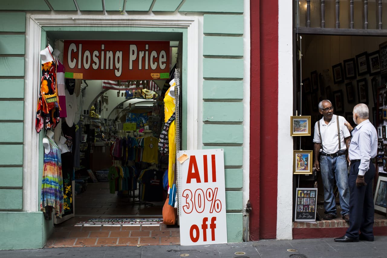 Dos hombres hablan afuera de una tienda en liquidación en el Viejo San Juan. 29 de abril de 2016.