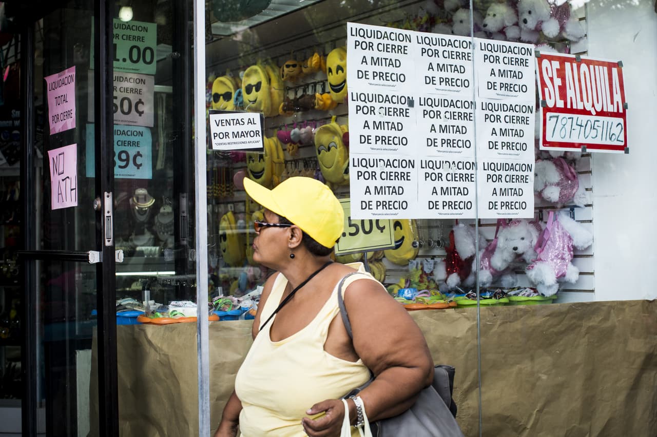 Una mujer camina frente a una tienda en liquidación en el vecindario Río Piedras. 30 de abril de 2016.