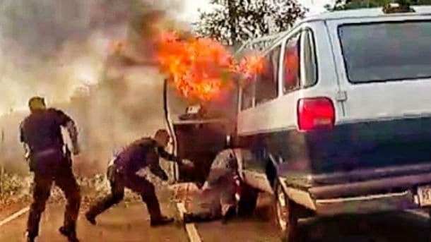 Policías de San José rescatan a la fuerza a un desamparado que se aferraba a una camioneta en llamas