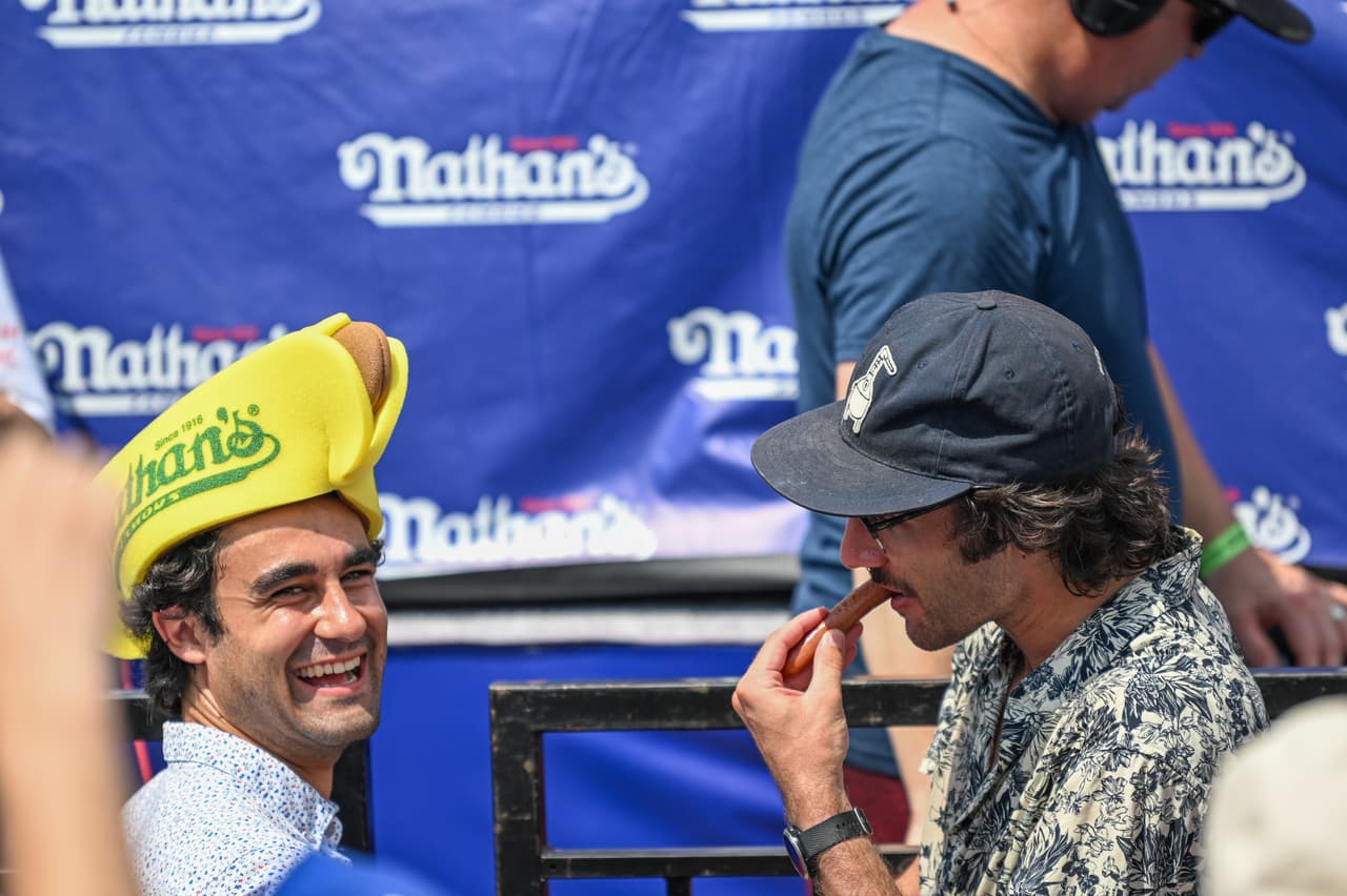 También es una oportunidad para disfrutar del platillo principal. Estos dos espectadores comen un perro caliente que les entregó el campeón Miki Sudo.