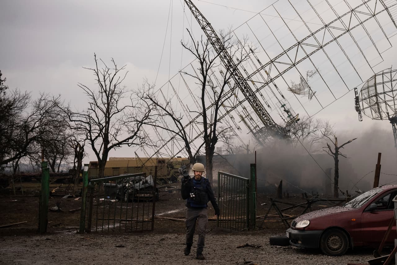 Associated Press videographer Mstyslav Chernov walks amid smoke rising from an air defense base in the aftermath of a Russian strike in Mariupol, Ukraine, Thursday, Feb. 24, 2022. (AP Photo/Evgeniy Maloletka)