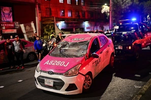 Los vagones cayeron sobre la calzada. En la imagen se puede ver cómo una grúa se lleva a 
<b>un taxi dañado en el accidente. </b>
<br>
