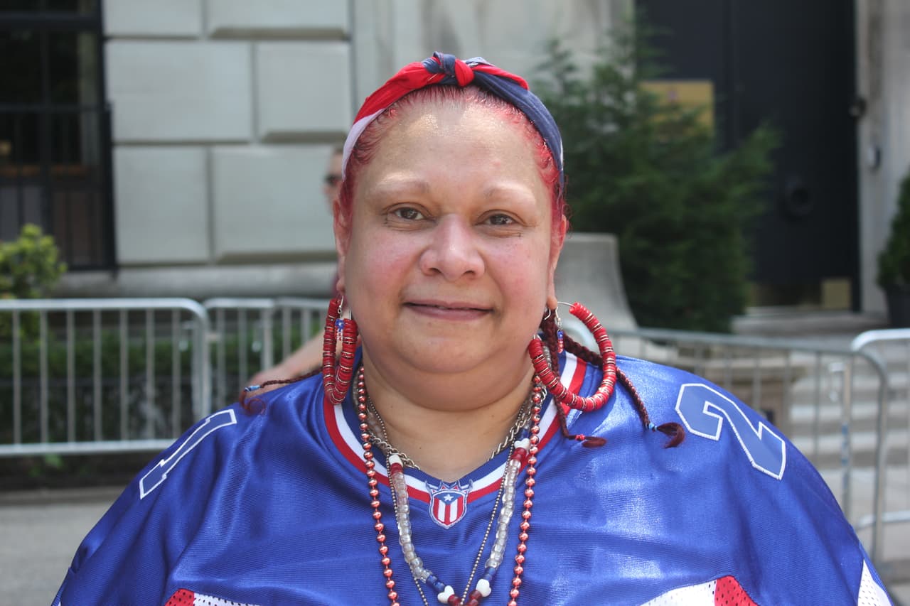 Belinda Rodríguez nació en el barrio del Bronx, Nueva York. Sus padre es del pueblo de Ponce, en el sur de Puerto Rico, y su madre de Caguas, en el este. Por esa sencilla razón ella se aposta cada año en alguna acera de la Quinta Avenida para celebrar a su isla. “Mi familia es de PR (...) y para mí es un orgullo estar aquí", dijo enfundada en una camisa, turbante e incluso aretes con la bandera monoestrellada. (Patricia Vélez/Univision Noticias)