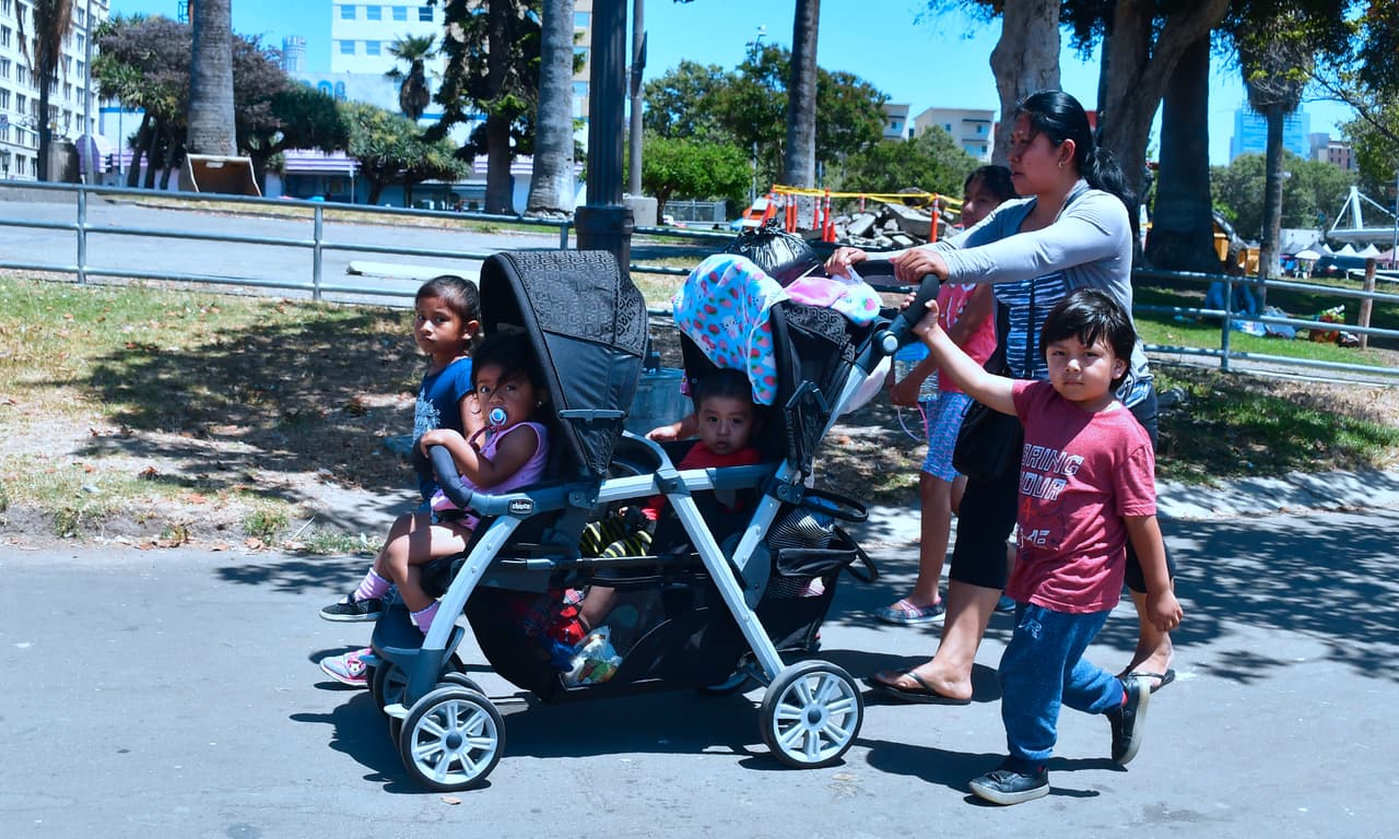 Babysitter Eusebia, from Guatemala, walks with children through MacArthur Park in the predominantly Hispanic/Latino neighborhood of Westlake in Los Angeles, California on June 19, 2018. - From cleaning ladies to construction workers to activists, members of LA's huge Latino community say they are horrified by the zero tolerance policy that has led to children being separated from their parents. (Photo by Frederic J. BROWN / AFP) / With AFP Story by Javier TOVAR: US-politics-immigration-children-trauma-health-research (Photo credit should read FREDERIC J. BROWN/AFP/Getty Images)