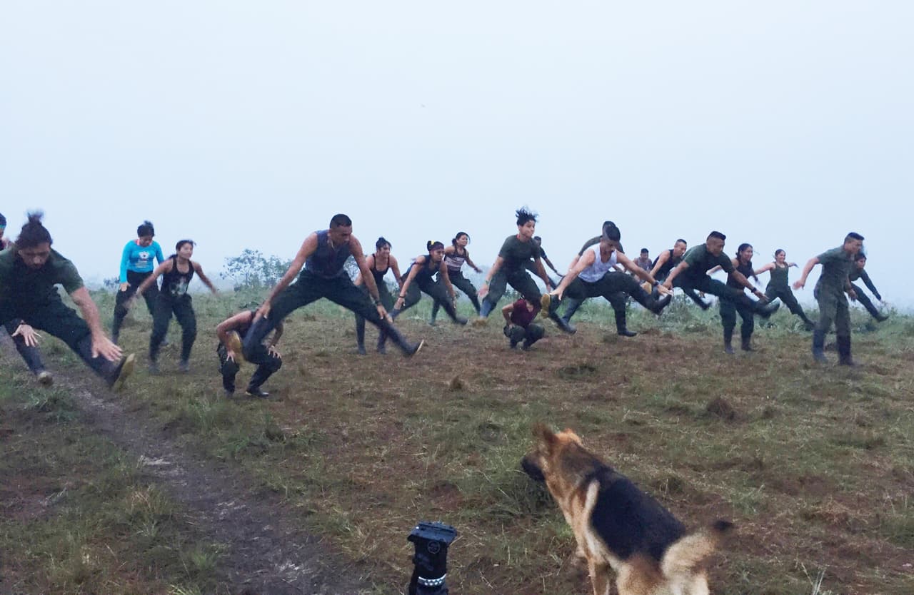 FARC fighters do early morning exercise routine in southern Colombia, as Bruno, a German Shepherd dog looks on.