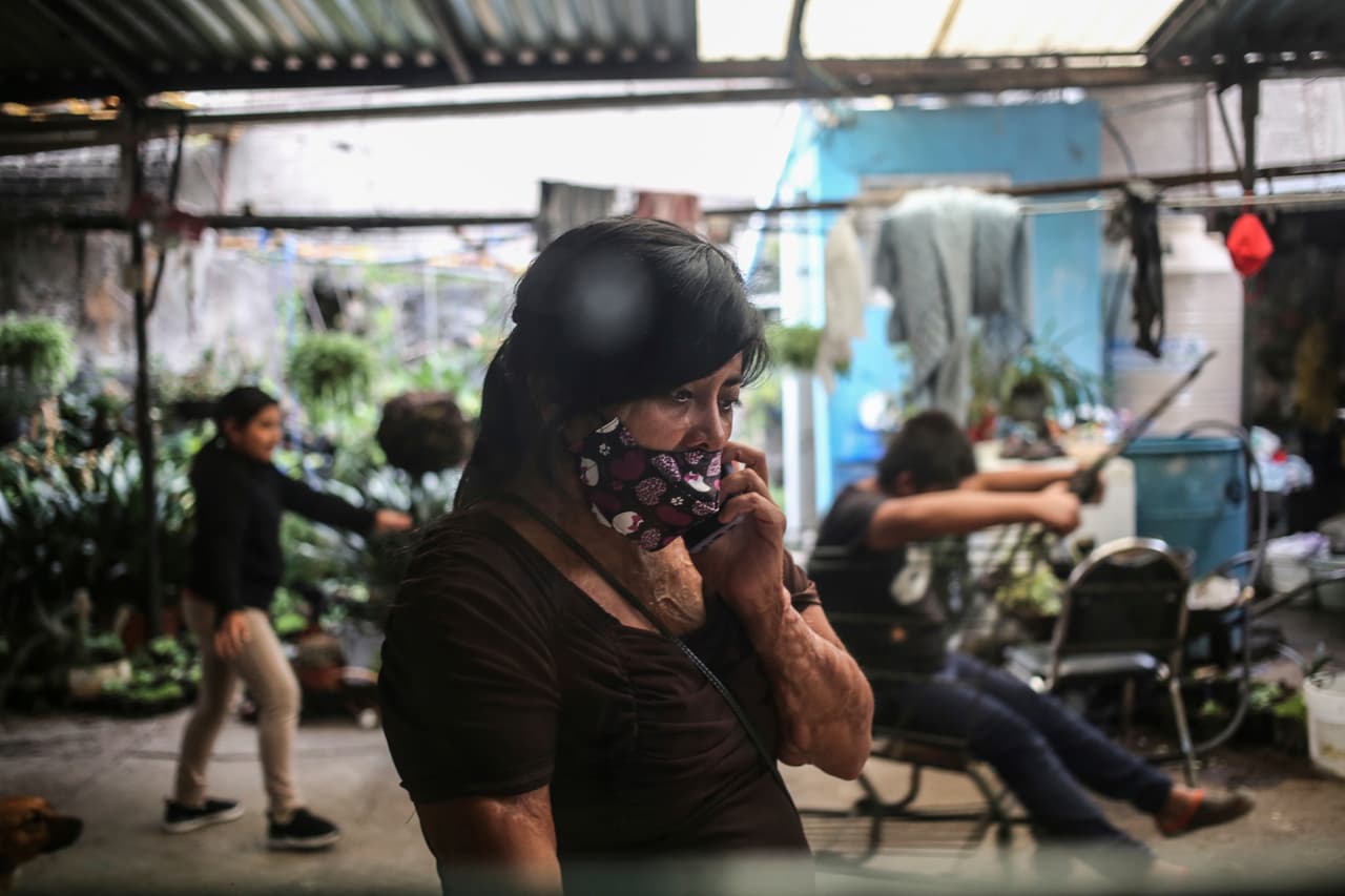 Elisa habla por celular mientras sus hijos juegan en la casa de sus padres en la Ciudad de México.